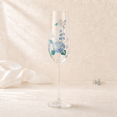 Single hand-painted blue hydrangea champagne flute with delicate floral details on a soft cream background