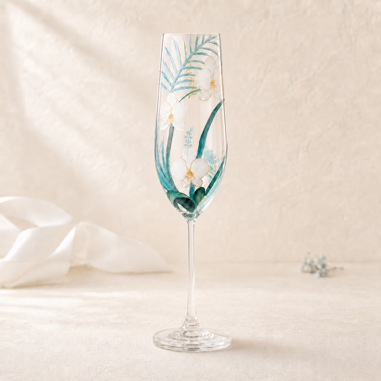 Hand-painted white orchid champagne flute with teal tropical leaves and gold details