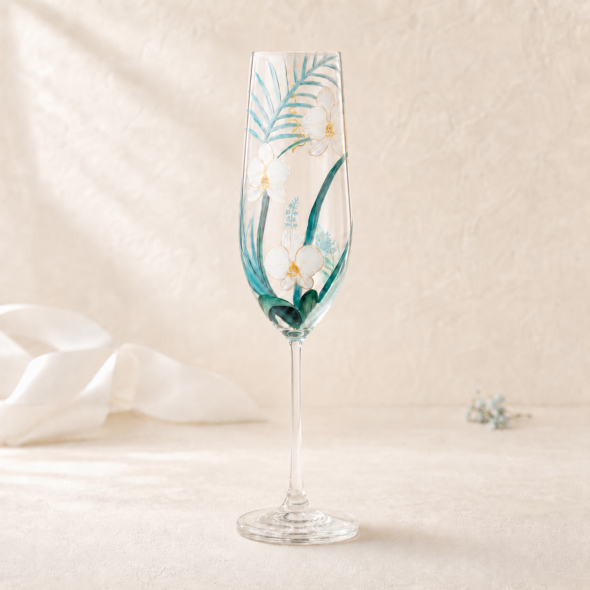 Hand-painted white orchid champagne flute with teal tropical leaves and gold details
